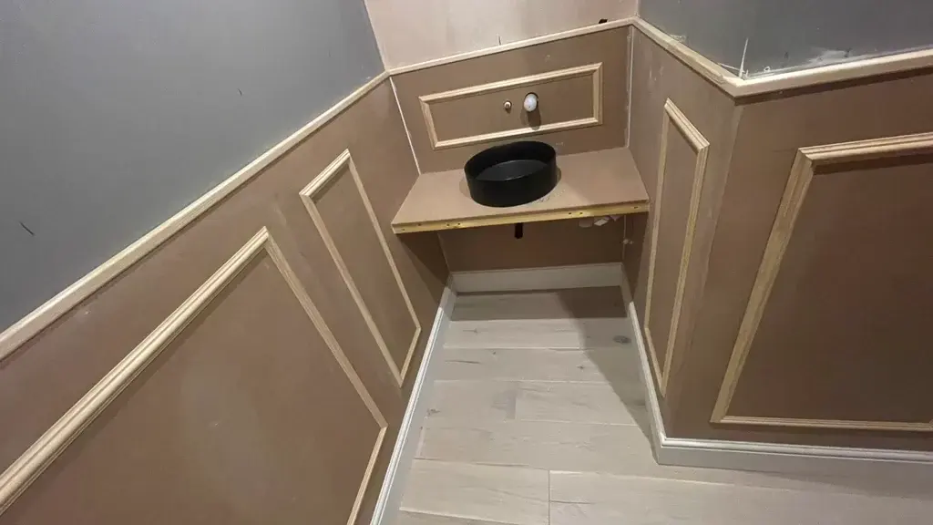 Bespoke MDF wall panelling with moulded beading and a fitted vanity in a cloakroom